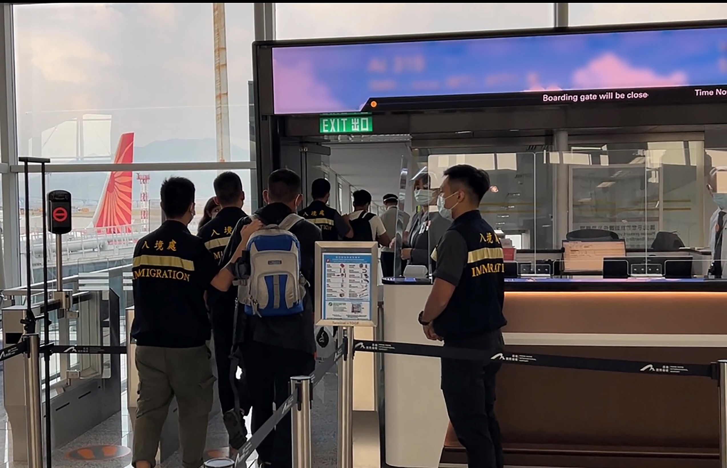 Photo shows a removee being escorted by ImmD officers to depart Hong Kong.