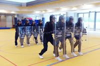 穿着防禦裝備的學員正在接受戰術訓練，並學習使用各種防禦裝備。