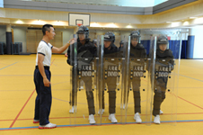 Trainees learning the proper use of different types of self-defense equipment.