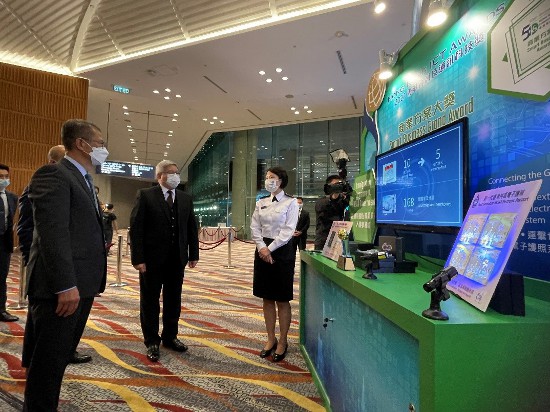 入境事務處處長區嘉宏（中）今日（十一月二十九日）晚上在2021香港資訊及通訊科技獎頒獎典禮陪同財政司司長陳茂波（左）聆聽入境處人員介紹「新一代電子護照系統」。