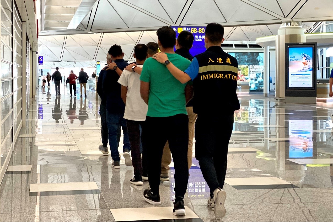 Photo shows removees being escorted by ImmD officers to depart Hong Kong.