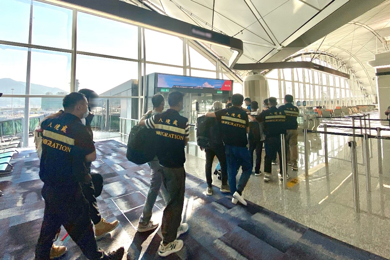 Photo shows removees being escorted by ImmD officers to depart Hong Kong.