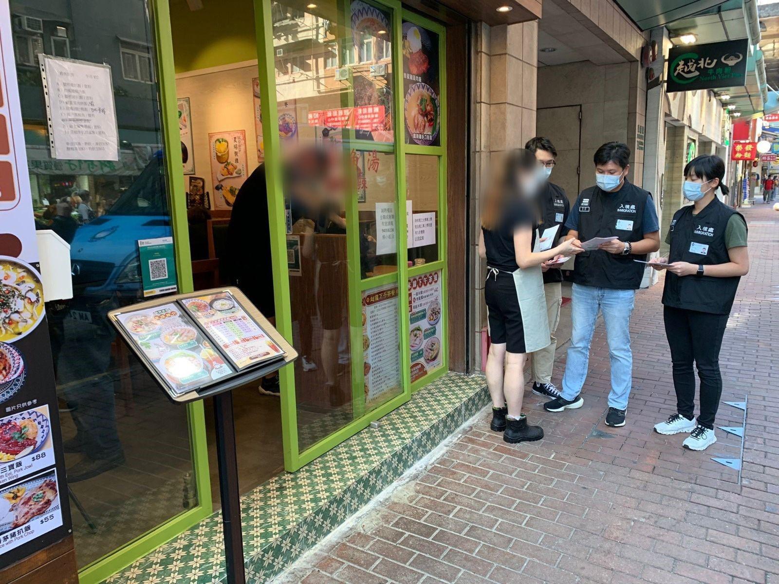 Photo shows Immigration investigation sub-division officers distributing “Don't Employ Illegal Workers” leaflets to restaurant staff.