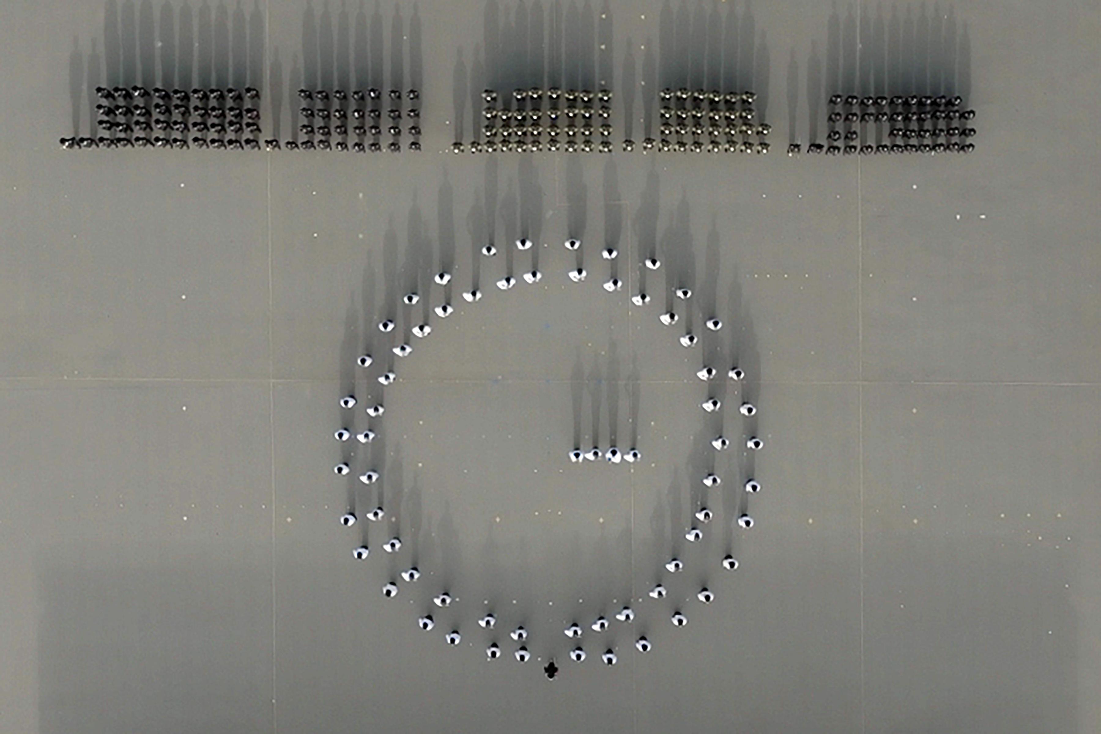 Photo shows the Guard of Honour marching to form a dynamic analogue clock, which symbolises the department's efforts to move with the times and strive for excellence.