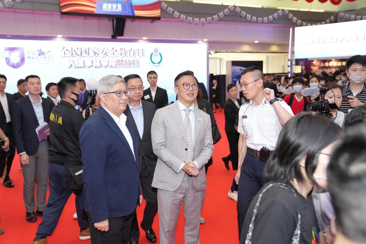 Photo shows the Deputy Secretary for Justice, Mr Cheung Kwok-kwan (front row, centre), accompanied by the Director of Immigration, Mr Au Ka-wang (front row, left), visiting an exhibition booth.