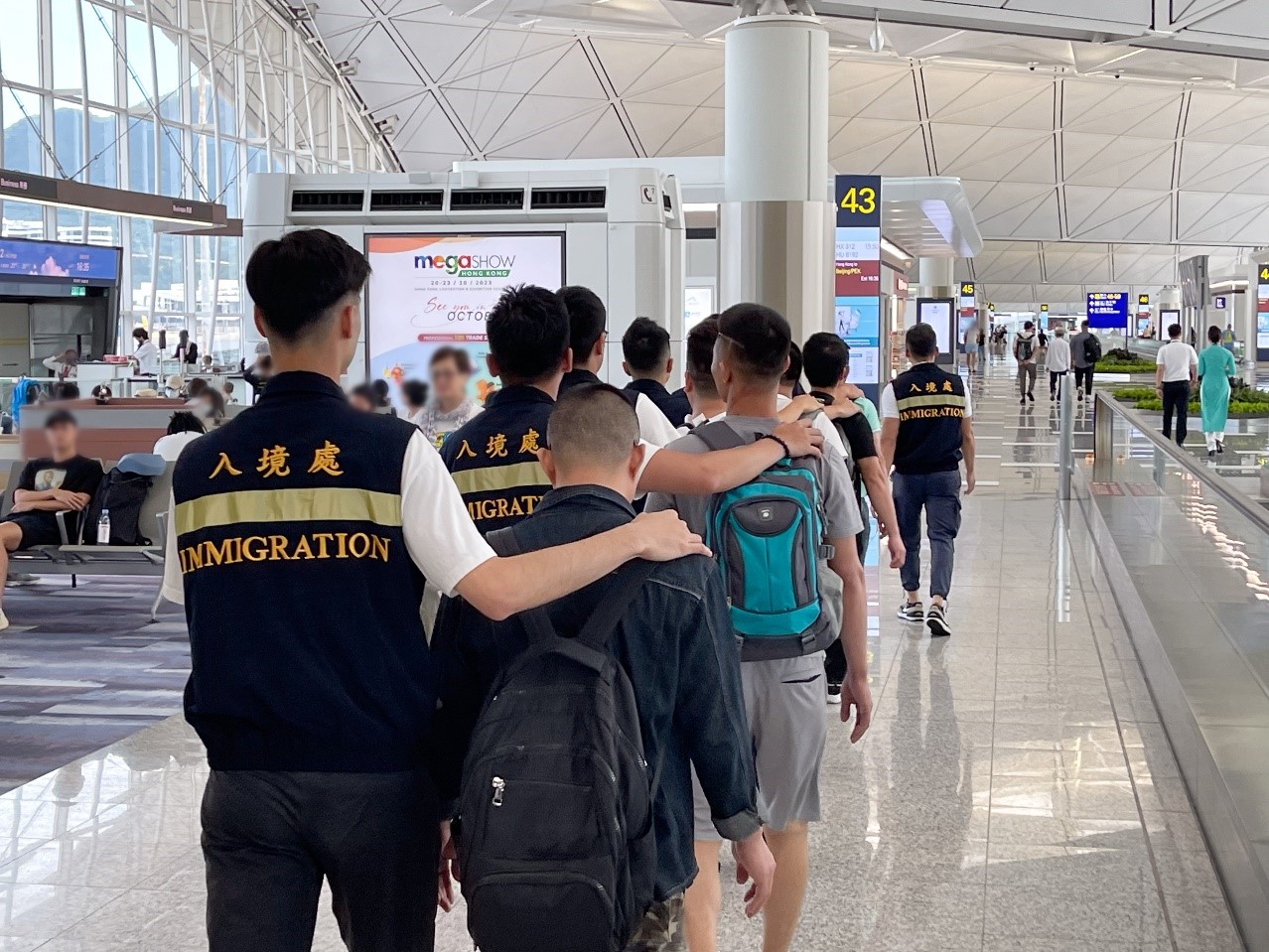 Photo shows removees being escorted by ImmD officers to depart from Hong Kong.