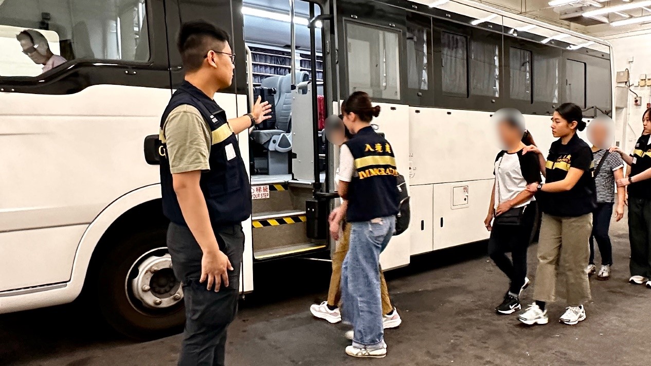 Photo shows removees being escorted by ImmD officers to proceed from the detention place to the airport.