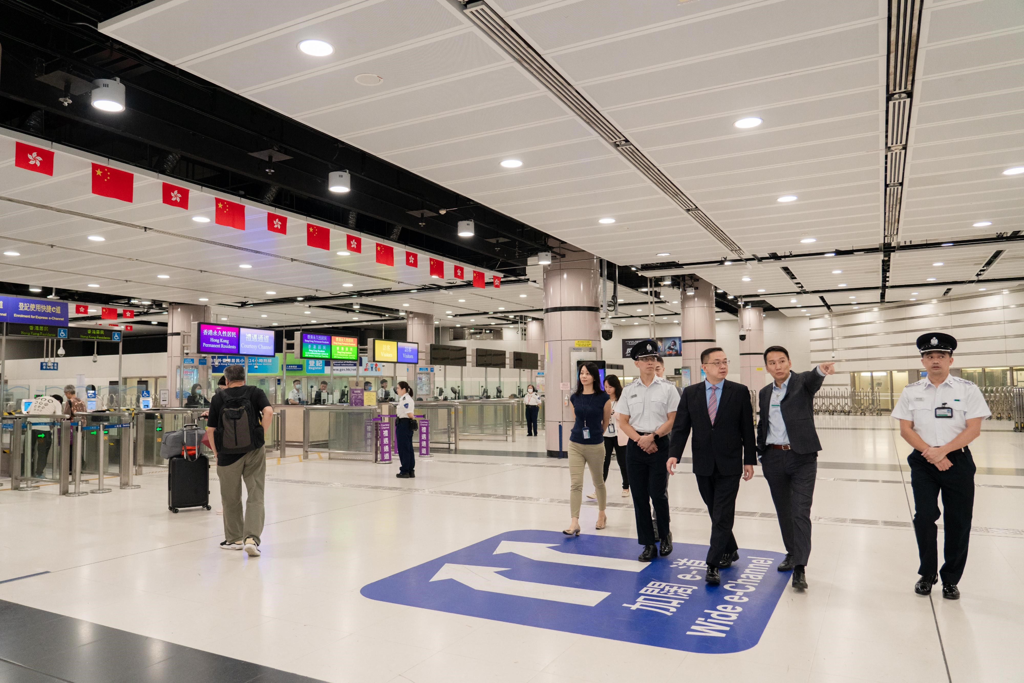 Photo shows Mr Kwok (third right) visiting the departure hall of the Lok Ma Chau Spur Line Control Point.