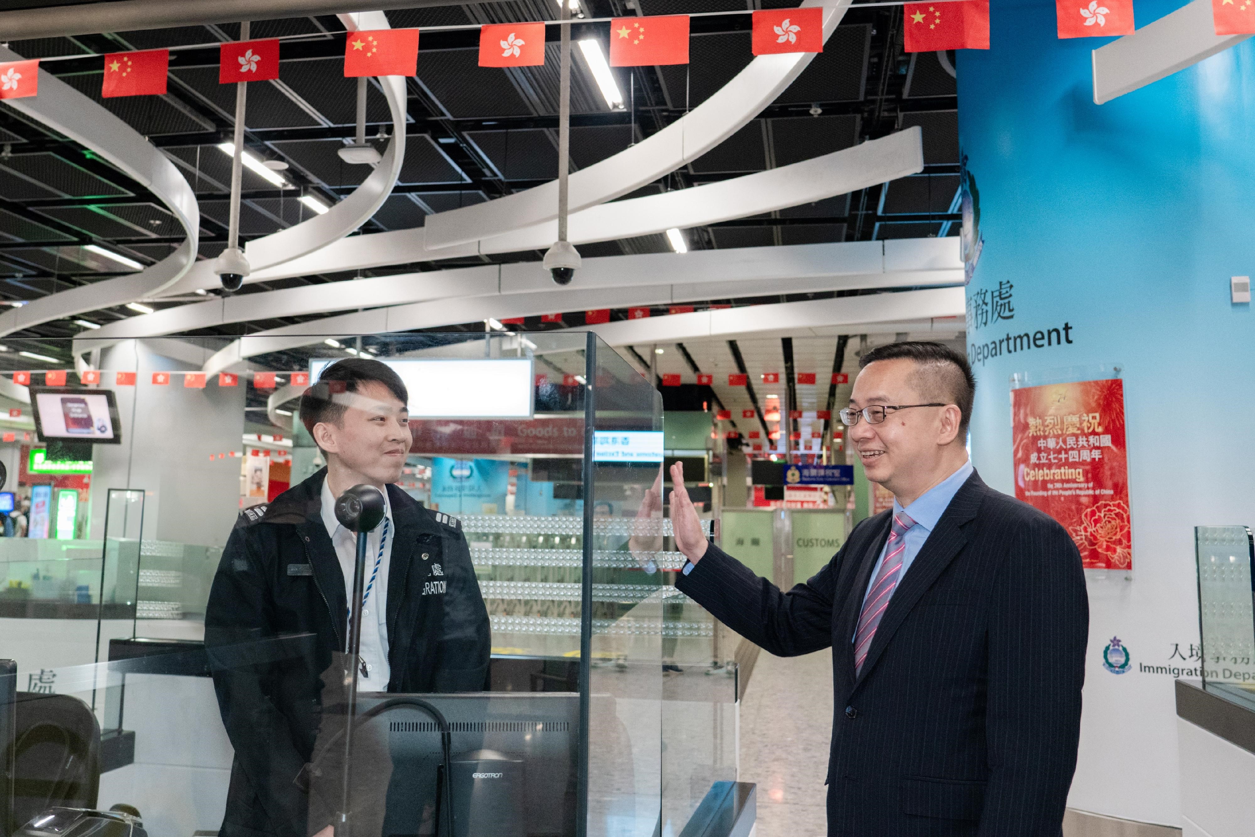 Photo shows Mr Kwok (right) showing support for a frontline officer at the Express Rail Link West Kowloon Control Point.