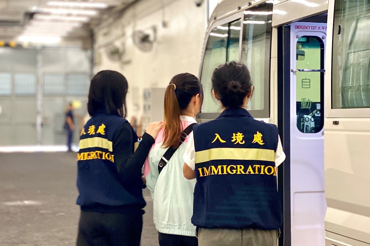 Photo shows removees being escorted by ImmD officers to proceed from the detention place to the airport.