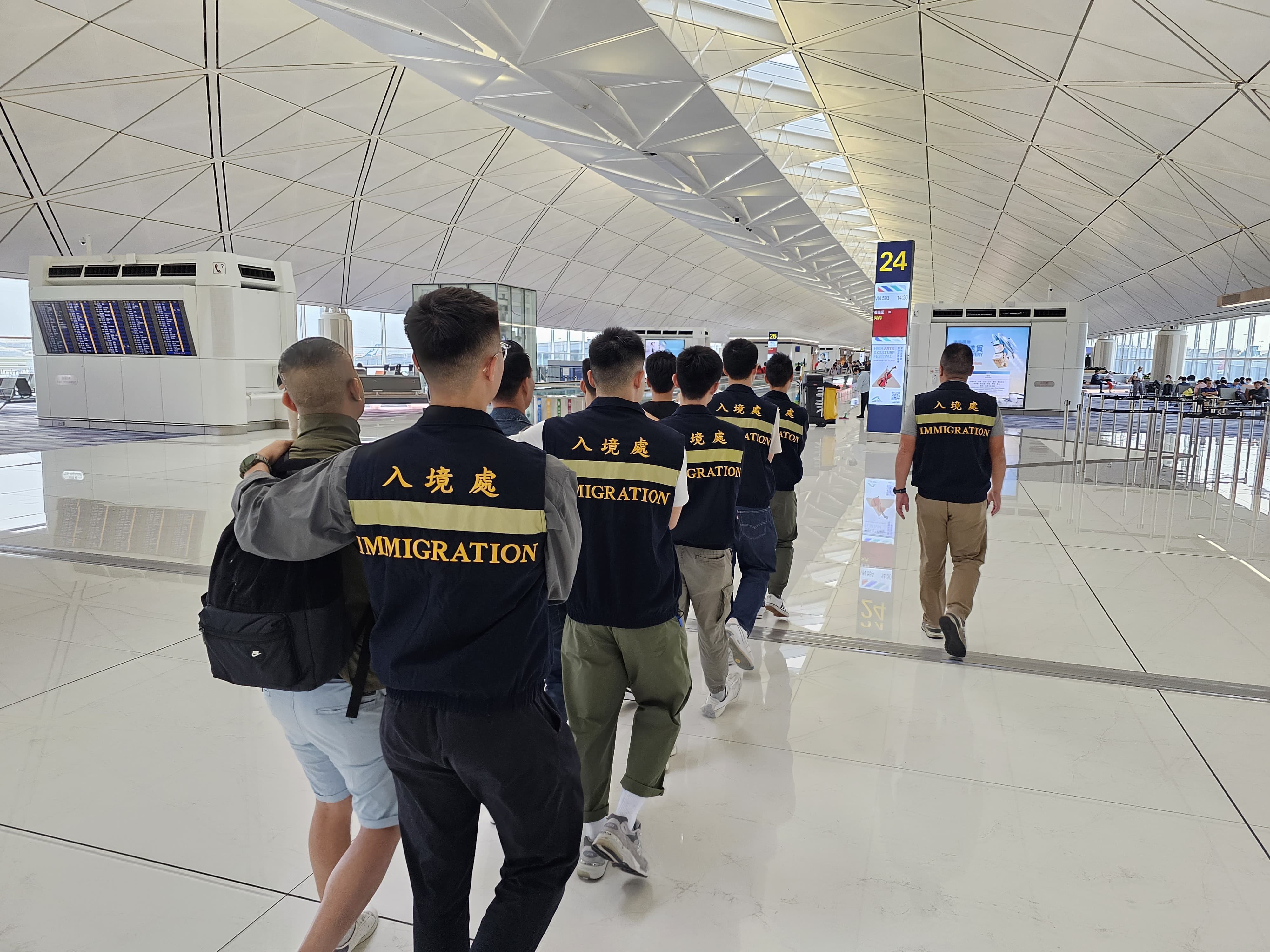 Photo shows removees being escorted by ImmD officers to depart from Hong Kong.