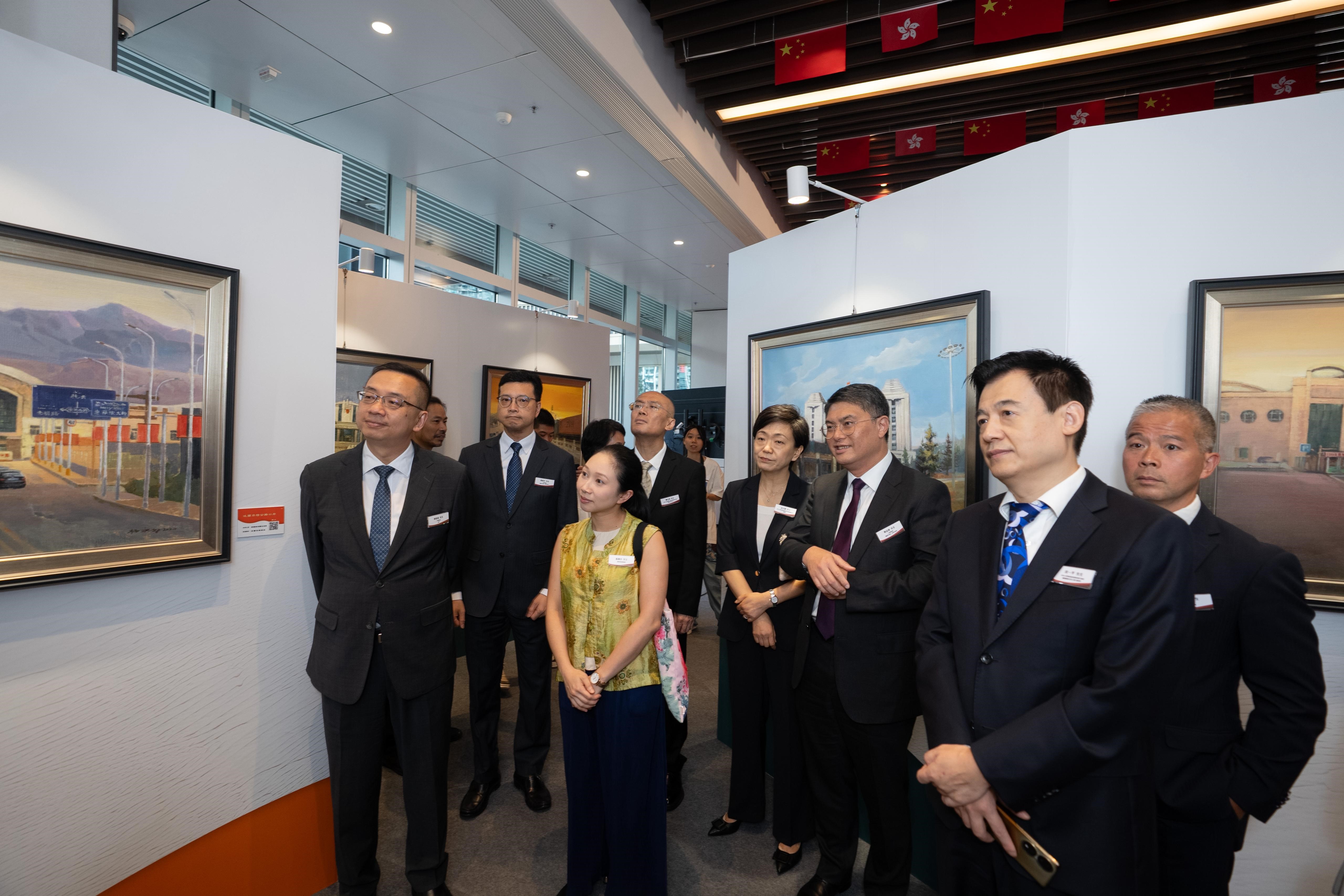 圖示入境處處長郭俊峯(左一)與嘉賓參觀油畫展