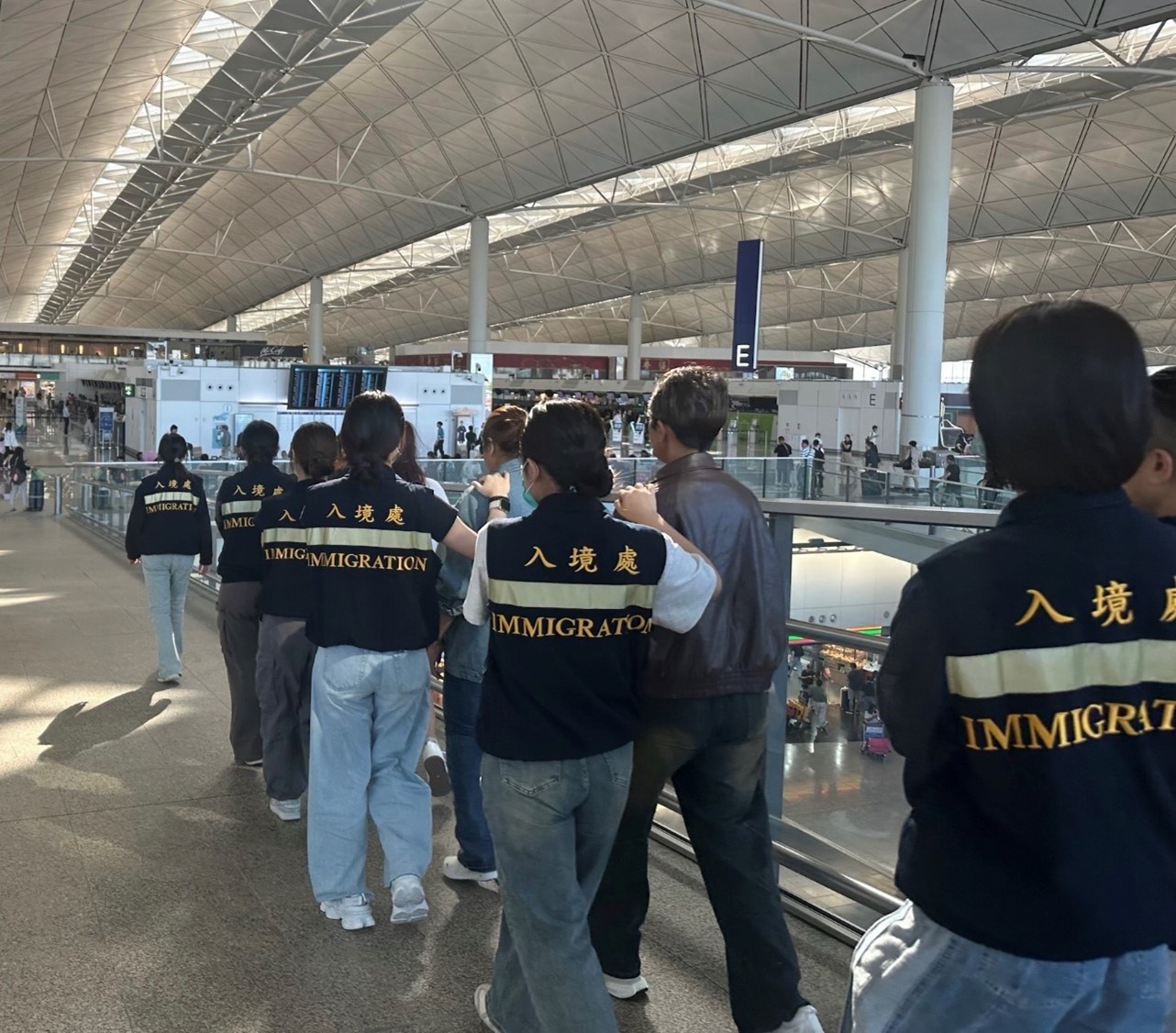 Photo shows removees being escorted by ImmD officers to depart from Hong Kong