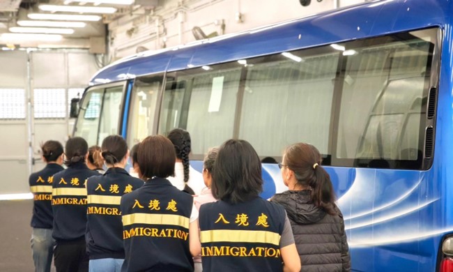 Photo shows removees being escorted by ImmD officers to proceed from the detention place to the airport