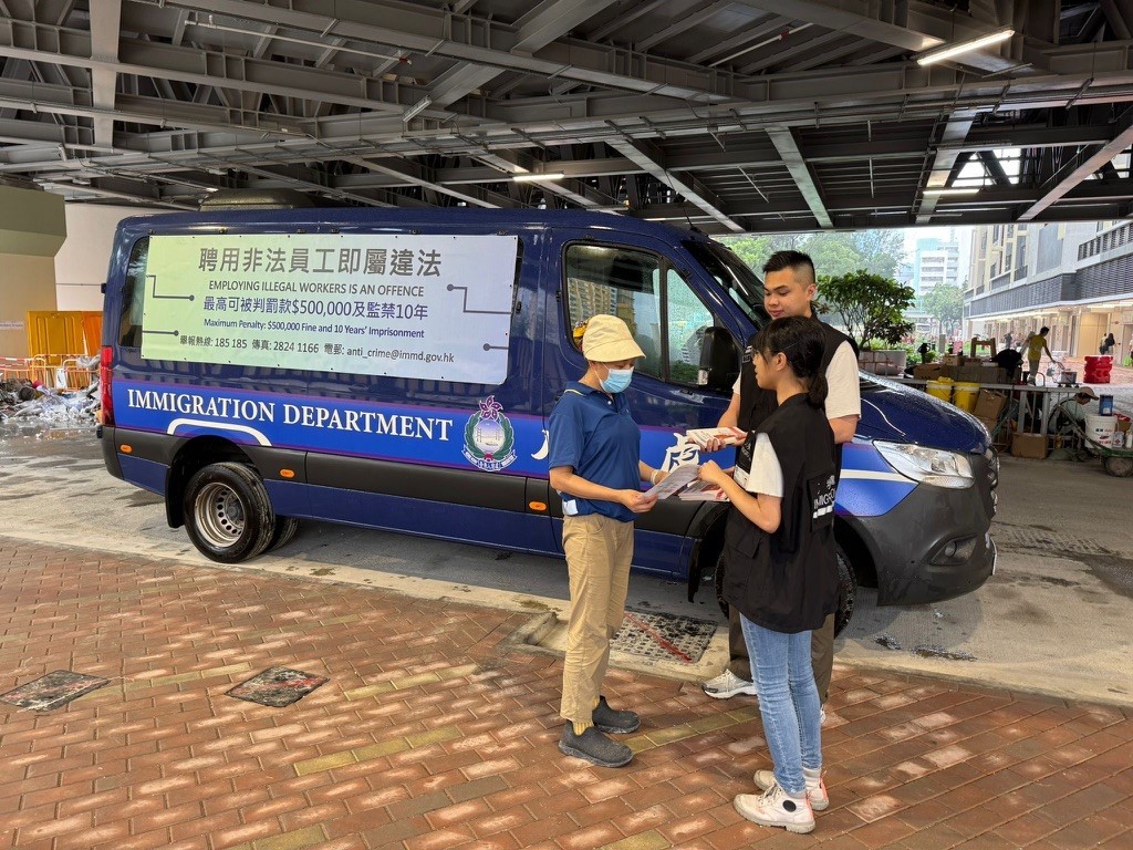 Photo shows Immigration officers distributing