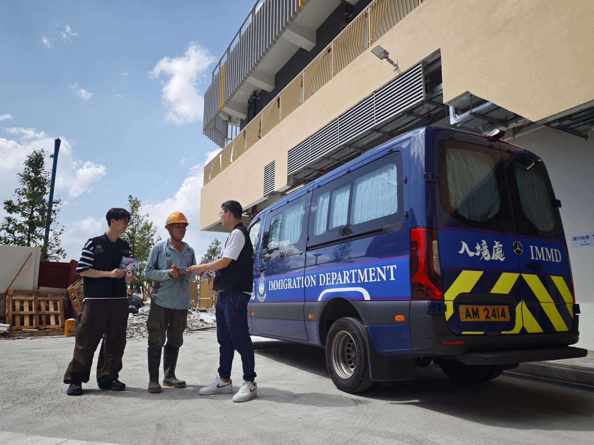 Photo shows ImmD officers distributing "Don