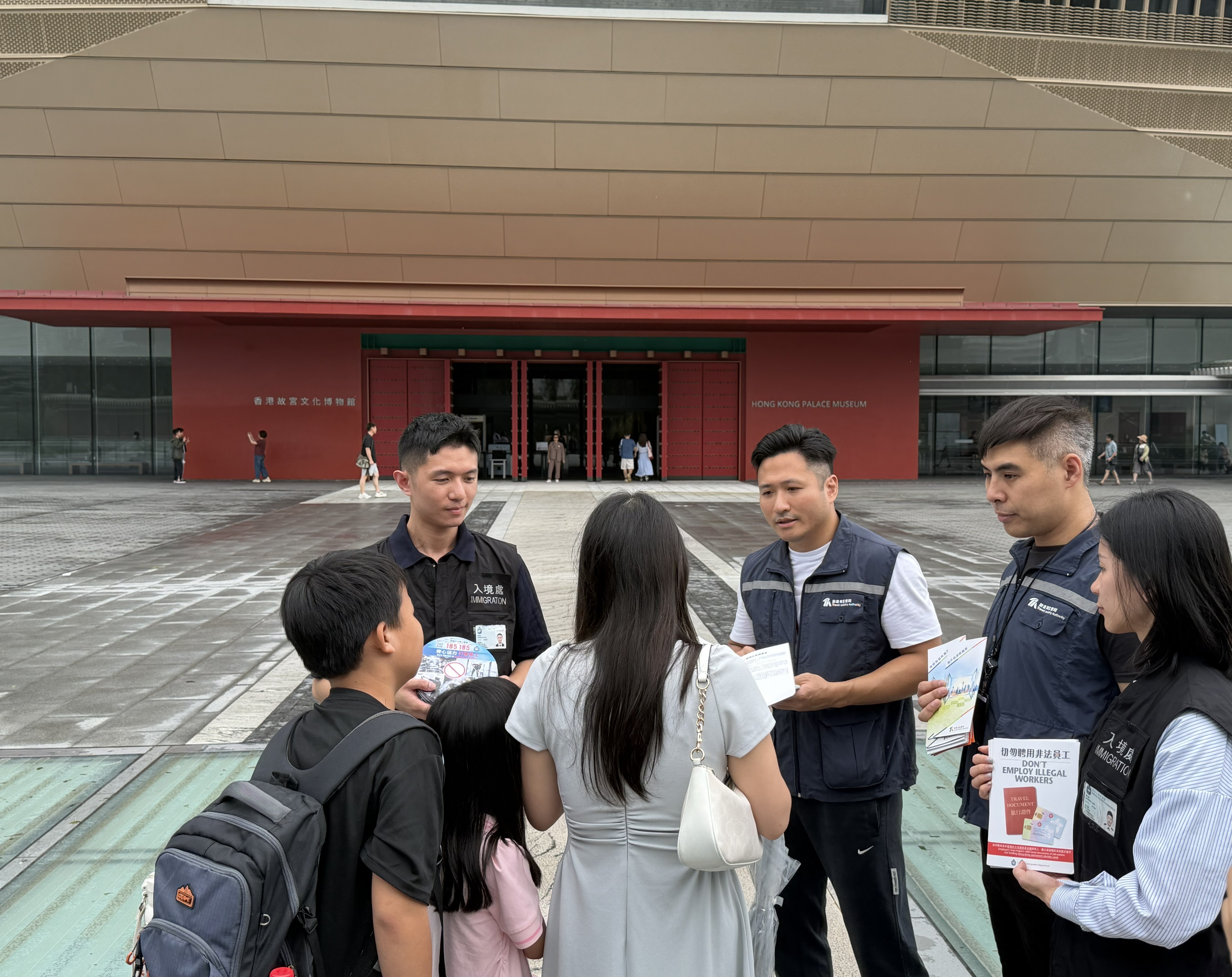 Photo shows officers from the ImmD and the TIA distributing leaflets to the public and visitors, conveying the message of "Don
