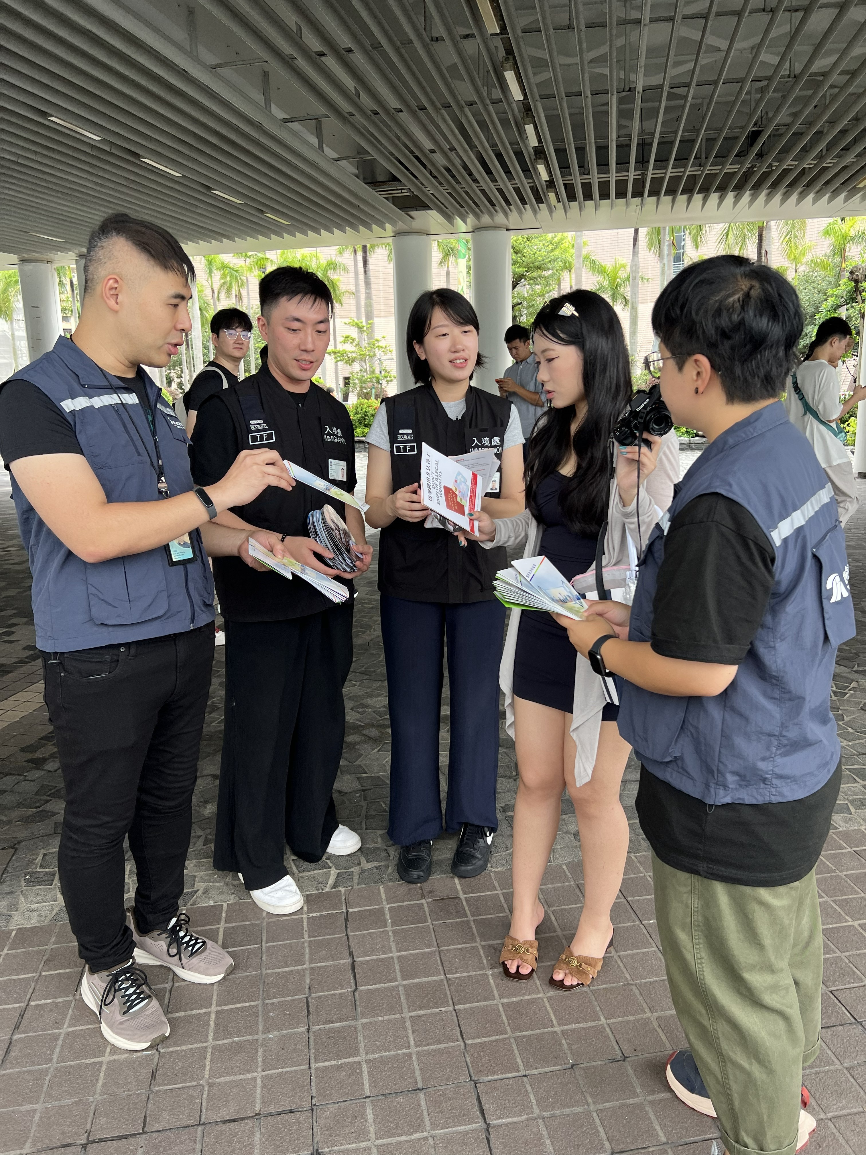 Photo shows officers from the ImmD and the TIA distributing leaflets to the public and visitors, conveying the message of "Don