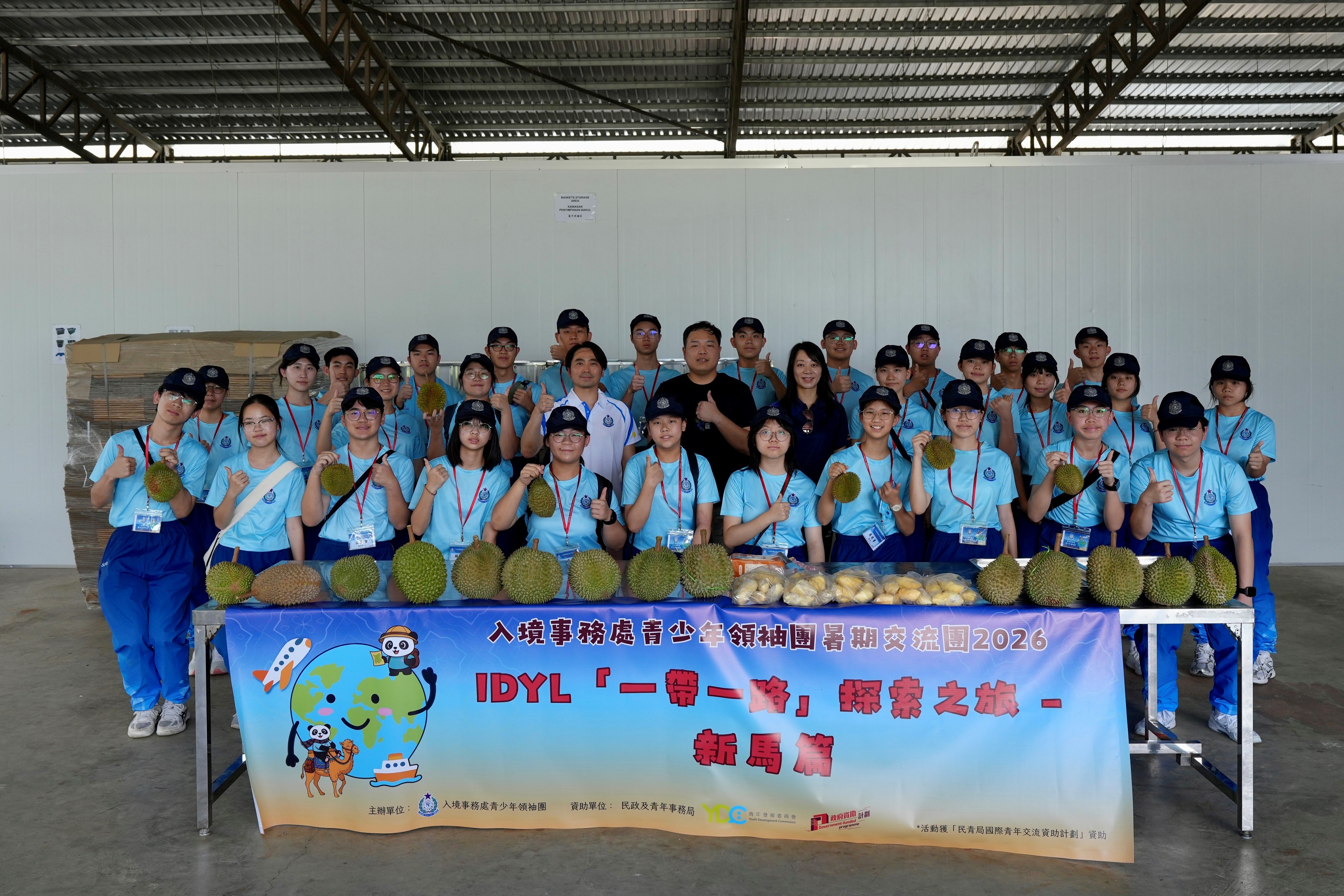 The Commandant of the Immigration Service Institute of Training and Development, Ms Lam Huen-si (second row, sixth right), and Assistant Commissioner of the Immigration Department Youth Leaders Corps Advisory Committee Mr Fong Chun-kit (second row, fifth left) lead members of the IDYL Belt and Road Exploration Tours: Singapore and Malaysia Tour to Laifa's durian farm and frozen durian processing factory on August 6 to learn about how the Belt and Road Initiative promotes co-operation between Malaysian and China's companies to expand the sales market.