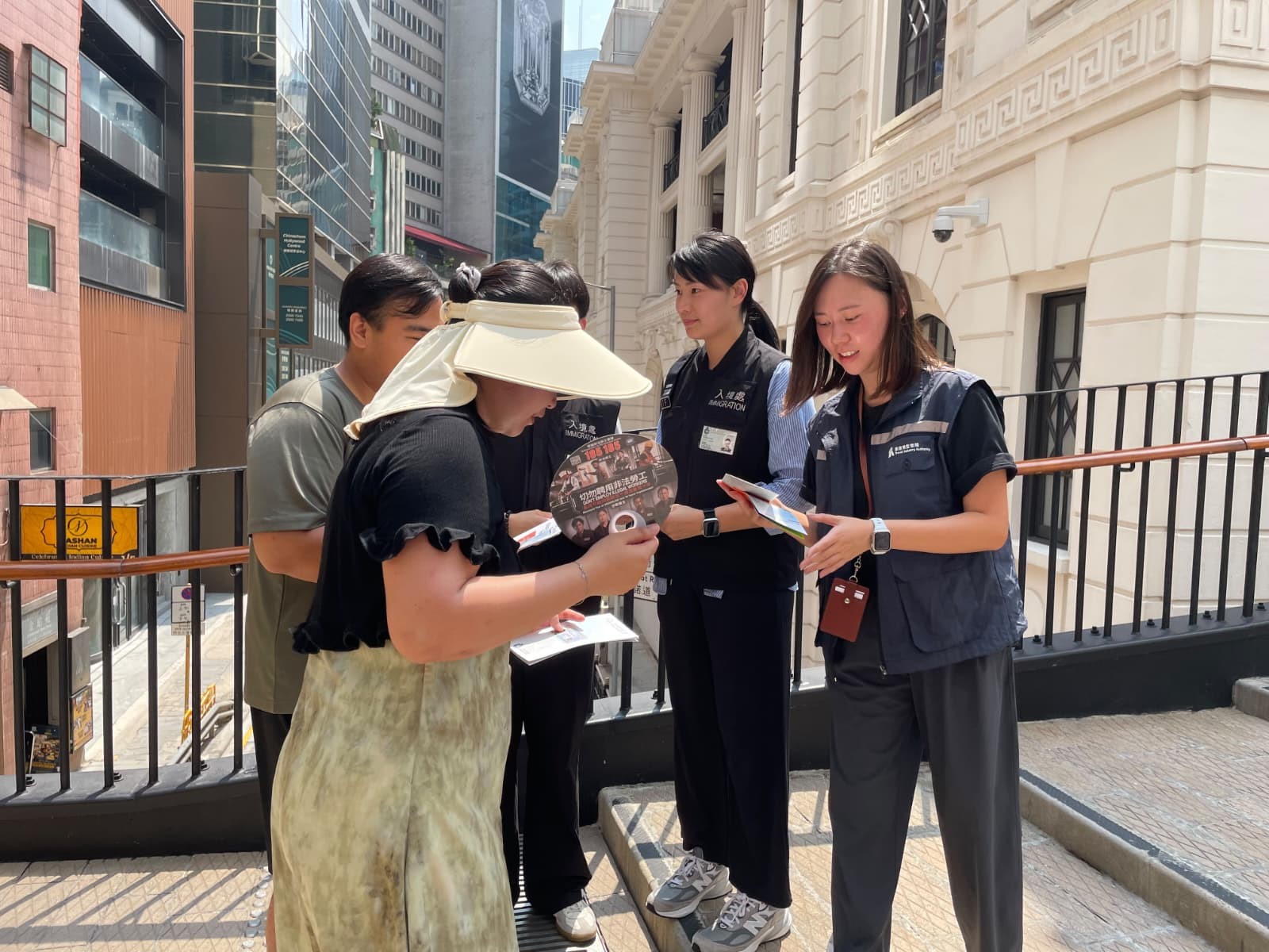 图示入境处及旅监局人员向市民及旅客派发宣传单张,呼吁切勿聘用非法领队或导游