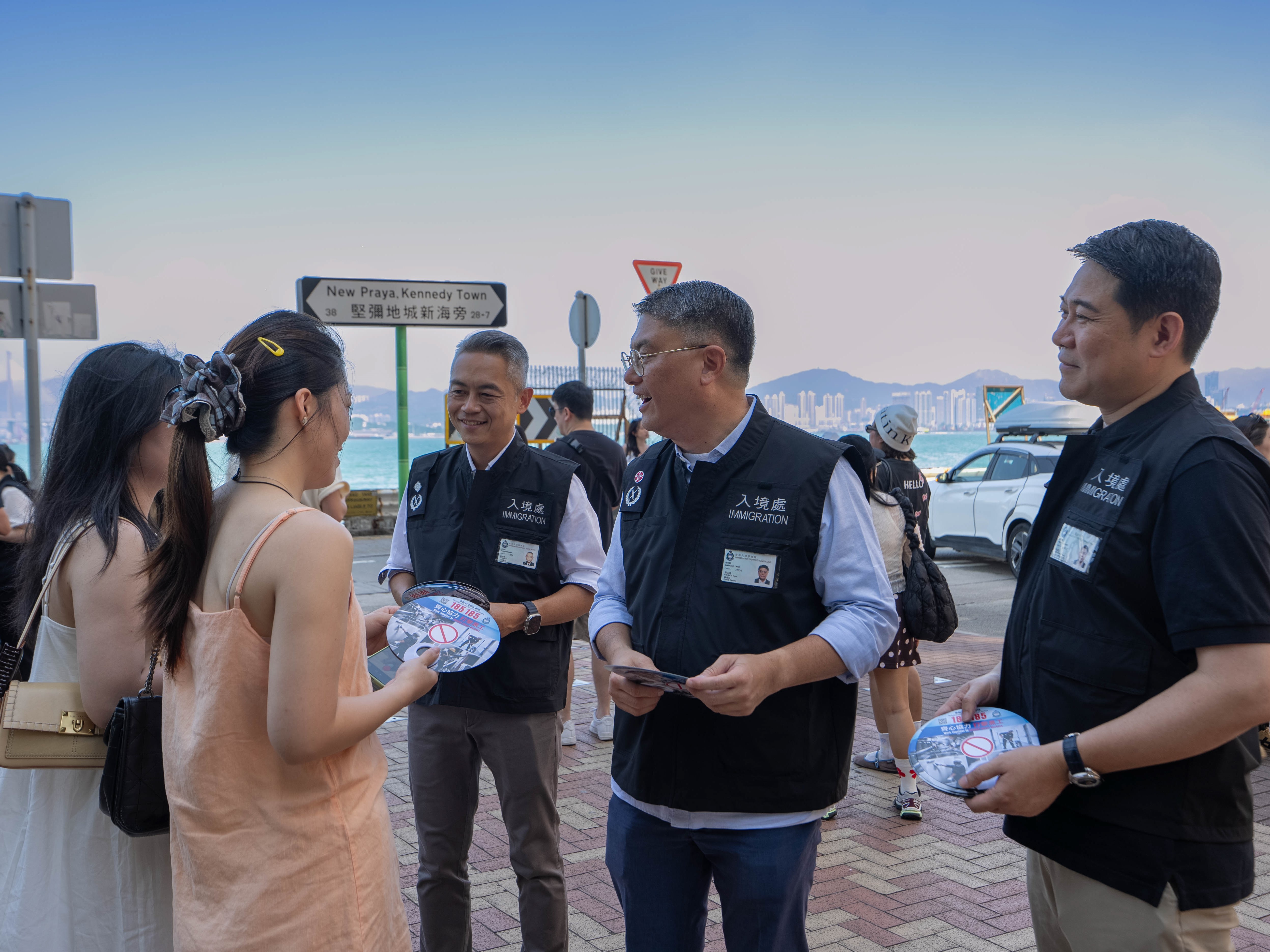 圖示入境處副處長(執法、系統及管理)蔡志遠(右二)、助理處長(執法)蘇駿豪(右三)及高級首席入境事務主任(執法)岑振忠(右一)帶領執法部同事到旅遊熱點,向市民及旅客派發宣傳單張,呼籲切勿聘用非法勞工