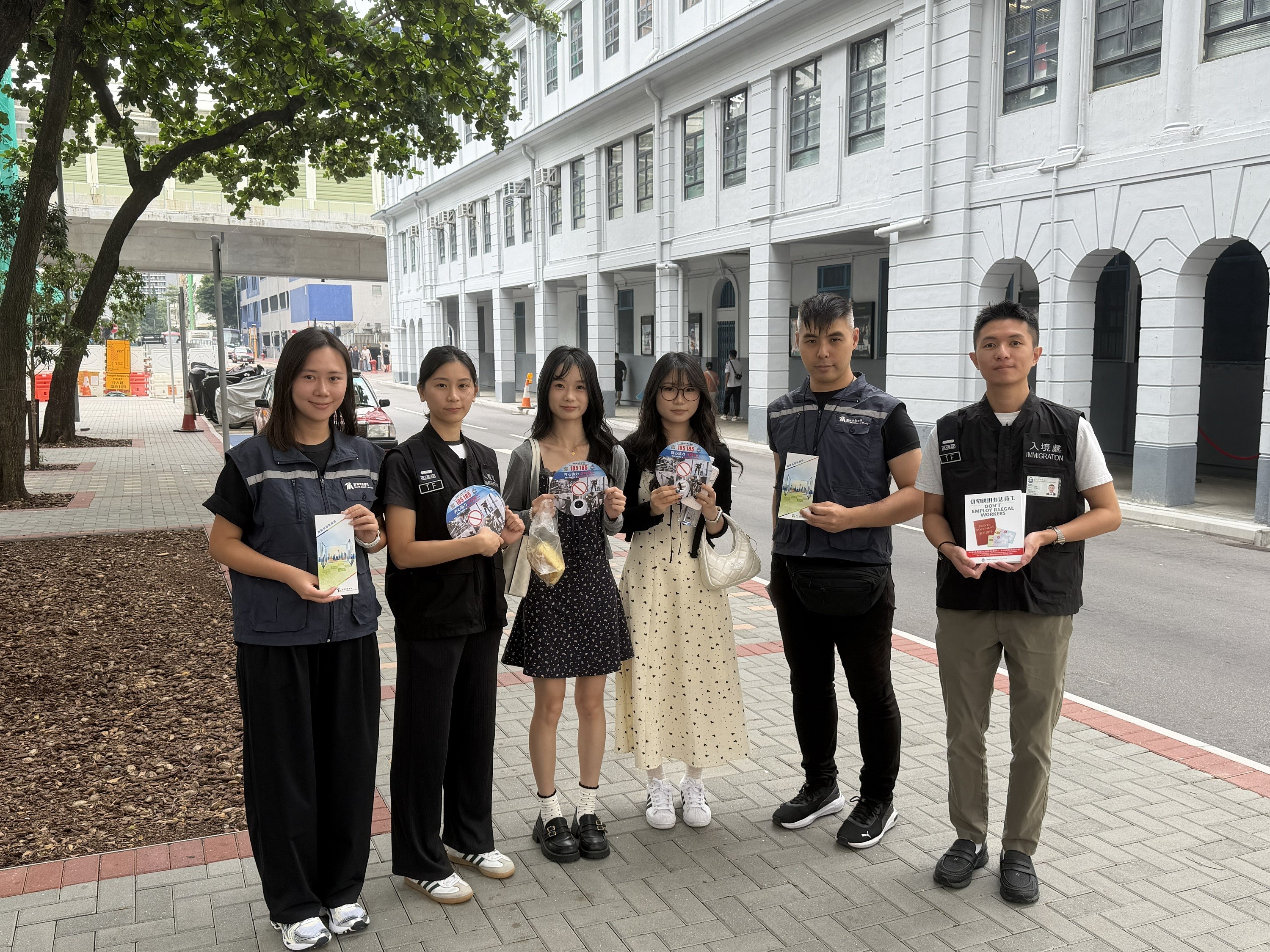 图示入境处及旅监局人员向市民及旅客派发宣传单张,呼吁切勿聘用非法领队或导游