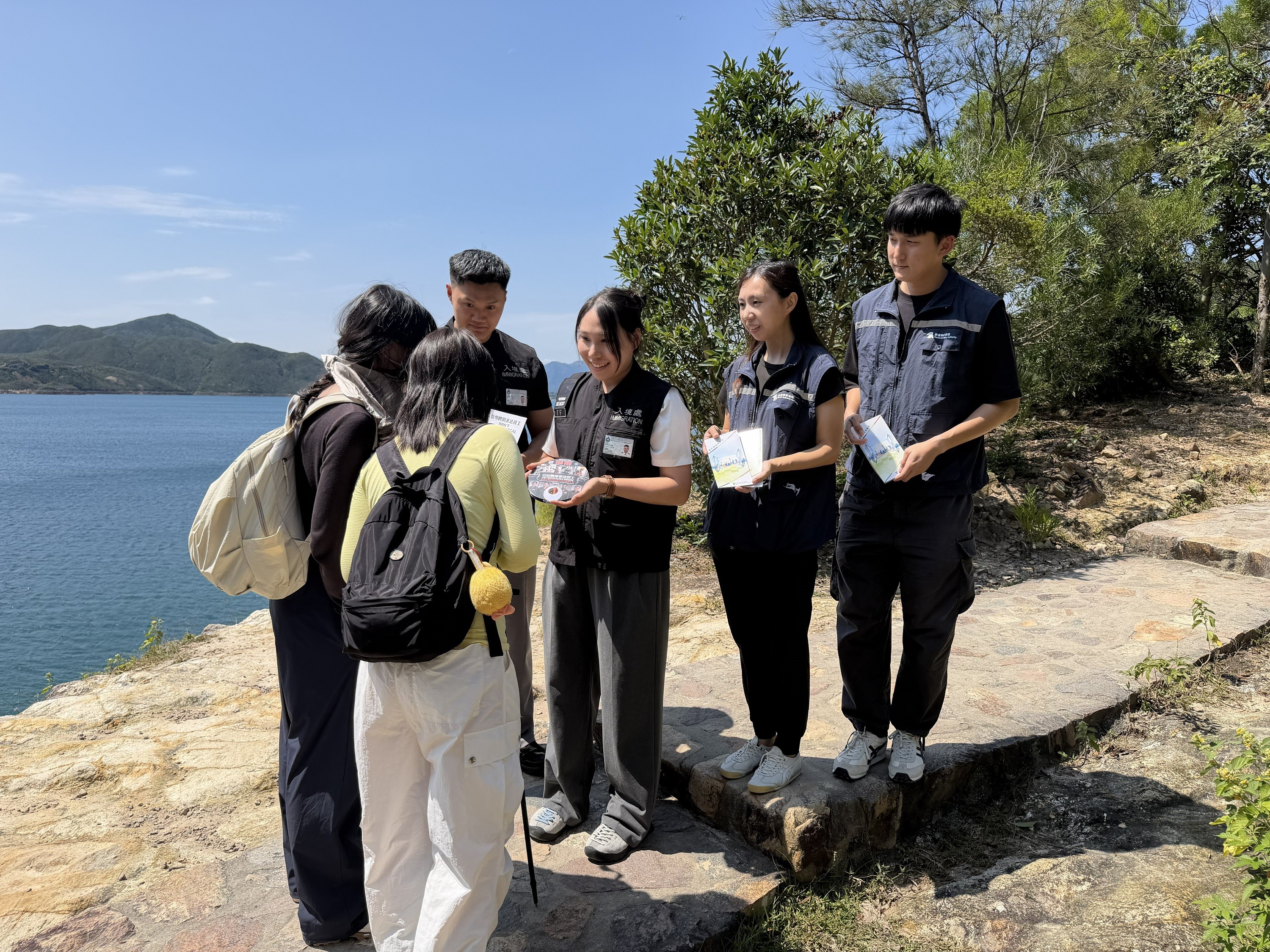 图示入境处及旅监局人员向市民及旅客派发宣传单张,呼吁切勿聘用非法领队或导游
